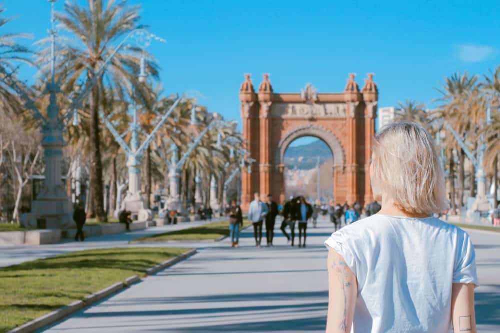 Eine Frau geht eine Straße in Barcelona, Spanien, entlang und erkundet die exklusiven Geschäfte und Luxushotels der Stadt.
